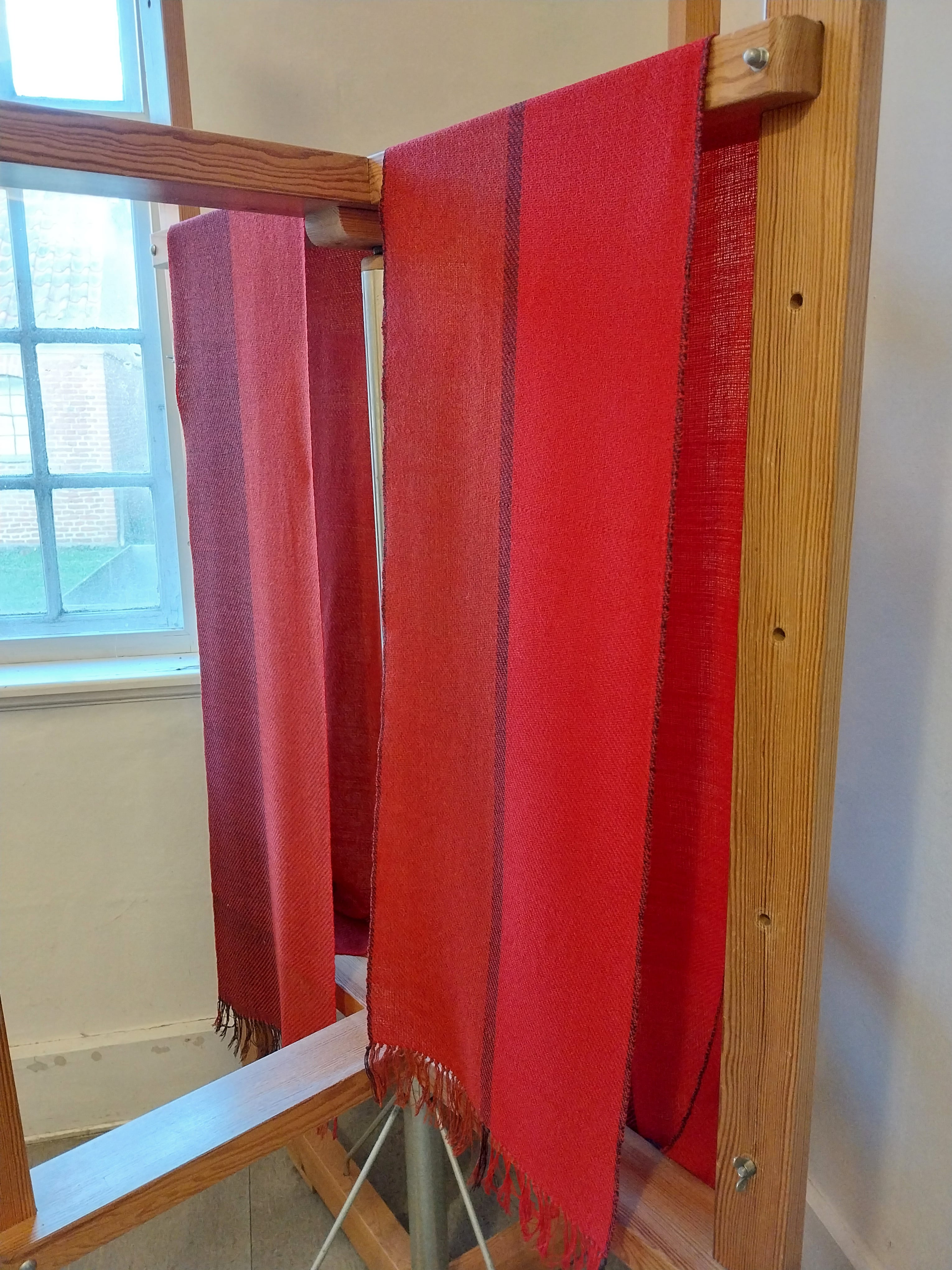 Brittas første tørklæder hænger til tørre, efter de er blevet dekateret (=dampet). Det ene har hun vævet på aftenskolekurset, det andet samtidig på sin væv derhjemme.